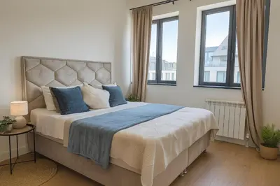 a bedroom with a large bed with blue pillows at Belgrade Waterfront - River Residences in Belgrade