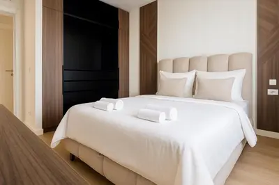 a bedroom with a large white bed with two towels on it at Belgrade Waterfront - River Residences in Belgrade