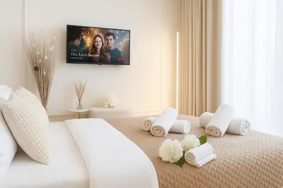 a white bed with towels and a tv on the wall at Belgrade Waterfront - River Residences in Belgrade