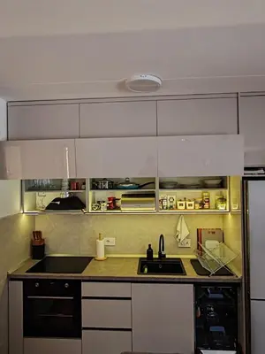 a kitchen with white cabinets and a black sink at Lux Star Belgrade in Belgrade