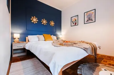 a bedroom with a large bed with blue walls at Indigo Spirit with Terrace & Foosball Old Town in Belgrade