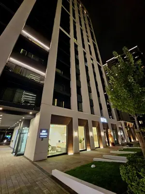 a tall building at night with its lights on at BW Maša in Belgrade