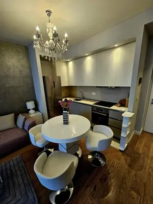 a kitchen with a table and chairs in a room at BW Maša in Belgrade