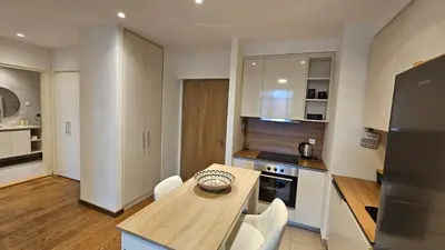 a kitchen with a wooden table and white cabinets at BW Ivona Apartment Beograd na vodi in Belgrade