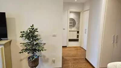 a living room with a plant in a vase on the floor at BW Ivona Apartment Beograd na vodi in Belgrade