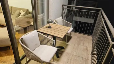 a balcony with a table and chairs and a couch at BW Ivona Apartment Beograd na vodi in Belgrade
