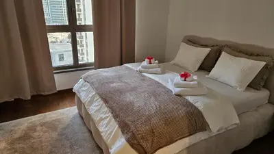 a bed with two towels on it with a window at BW Ivona Apartment Beograd na vodi in Belgrade