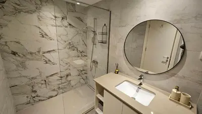 a bathroom with a sink and a shower with a mirror at BW Ivona Apartment Beograd na vodi in Belgrade