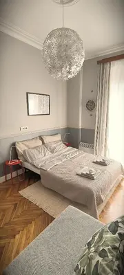 a bedroom with a large bed and a chandelier at Apartment JADesign Vračar, Belgrade in Belgrade