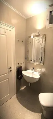 a bathroom with a sink and a toilet and a mirror at Apartment JADesign Vračar, Belgrade in Belgrade