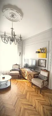 a living room with wooden floors and a chandelier at Apartment JADesign Vračar, Belgrade in Belgrade