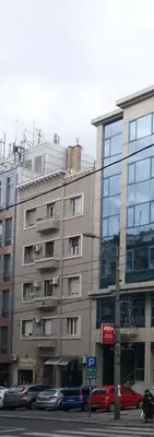 a tall building with cars parked in front of it at Apartment JADesign Vračar, Belgrade in Belgrade