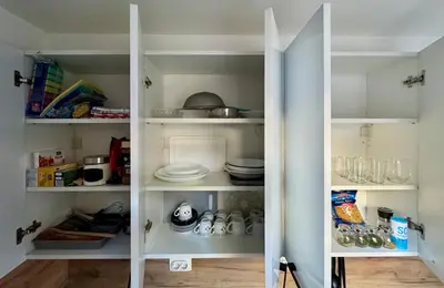 a white pantry with plates and dishes on shelves at Anywhere on Foot - FREE Parking in Belgrade