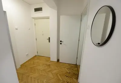 a hallway with a mirror and a wooden floor at Anywhere on Foot - FREE Parking in Belgrade