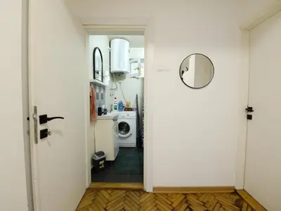 a hallway leading to a kitchen with a washing machine at Anywhere on Foot - FREE Parking in Belgrade