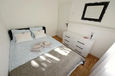 a bedroom with a bed and a dresser and a mirror at Anywhere on Foot - FREE Parking in Belgrade