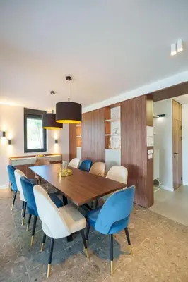 a dining room with a wooden table and blue chairs at Istros luxury house in Krčedin