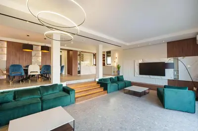 a living room with green couches and a television at Istros luxury house in Krčedin