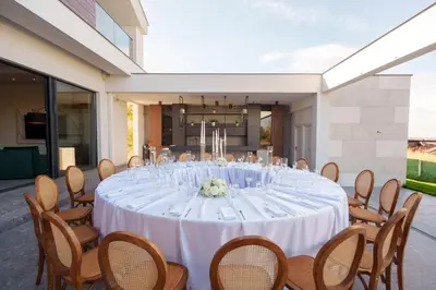 a long white table with chairs and wine glasses at Istros luxury house in Krčedin