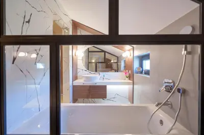 a bathroom with a tub and a sink and a mirror at Istros luxury house in Krčedin
