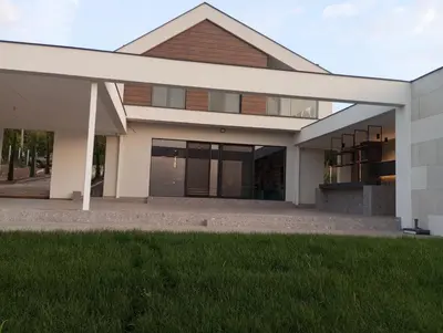a large house with a white facade and green grass at Istros luxury house in Krčedin