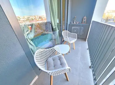 a balcony with two chairs and a table and a window at Metropoliten - Aria Lux Apartments BW in Belgrade