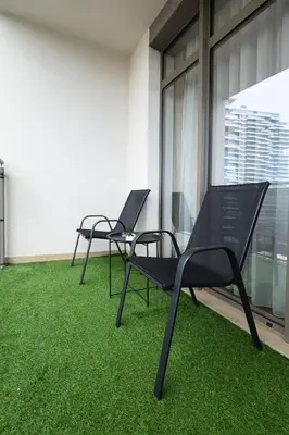 two chairs on a balcony with green grass at inJoy in Belgrade
