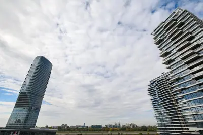 two tall buildings in a city under a cloudy sky at inJoy in Belgrade