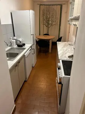 a kitchen with a white refrigerator and a table at Apt 1944 in Belgrade