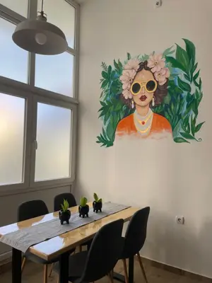 a dining room table with a painting of a woman at La Hitana in Lazarevac