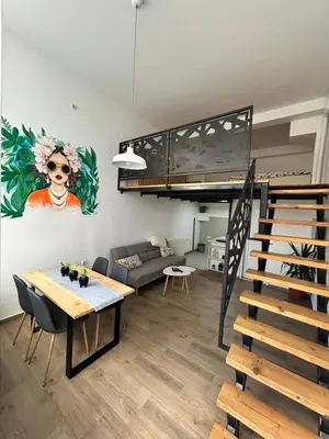 a living room with a loft bed and a dining table at La Hitana in Lazarevac