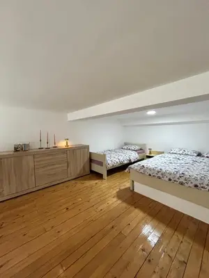 two beds in a room with wooden floors at La Hitana in Lazarevac