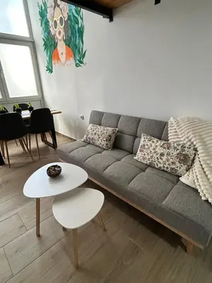a living room with a gray couch and a table at La Hitana in Lazarevac