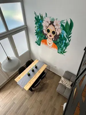 a room with a table and a painting on the wall at La Hitana in Lazarevac