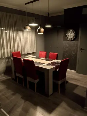 a dining room with a table and red chairs at Central Point Belgrade in Belgrade