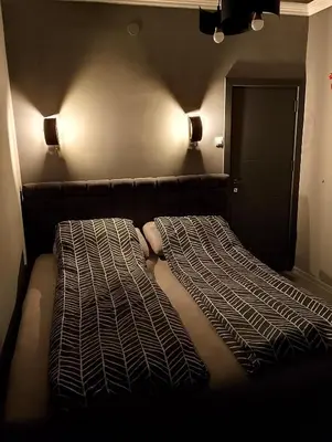 a bed in a room with two lights on the wall at Central Point Belgrade in Belgrade