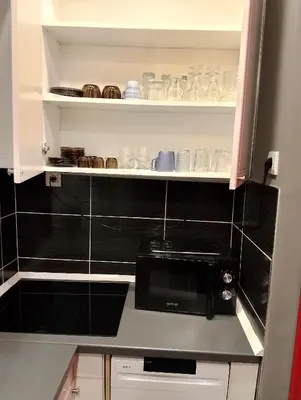 a kitchen with a black counter top with a microwave at Central Point Belgrade in Belgrade