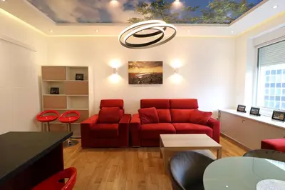 a living room with a red couch and red chairs at Grandeur Slavija in Belgrade
