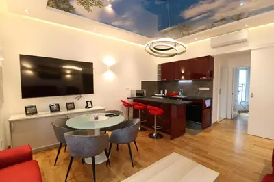 a kitchen and living room with a table and chairs at Grandeur Slavija in Belgrade