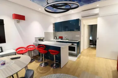 a kitchen with red bar stools and a table at Grandeur Slavija in Belgrade