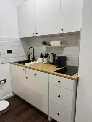 a kitchen with white cabinets and a counter top at Cozy apartment Kosmaj Residence in Rogača