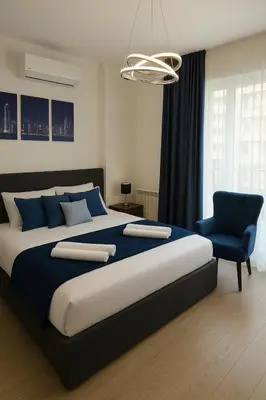 a bedroom with a large bed and a blue chair at Waterfront Studio Blue Lagoon in Belgrade