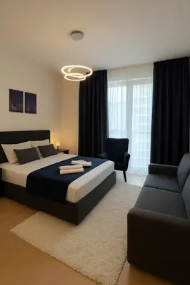 a bedroom with a king sized bed and a couch at Waterfront Studio Blue Lagoon in Belgrade