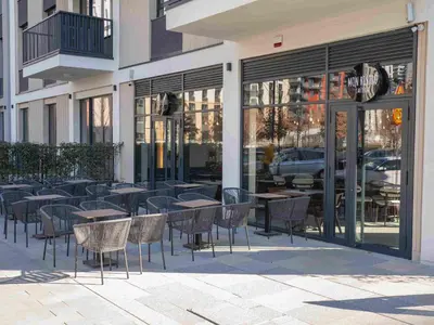 a group of tables and chairs in front of a building at Belgrade Waterfront - Urban Harmony Apartments in Belgrade