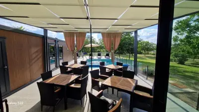 a patio with tables and chairs and a swimming pool at Niki Hill in Železnička Stanica Karlovački Vinogradi