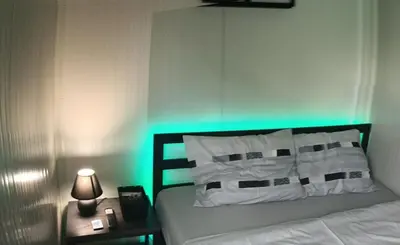 a bedroom with a bed with a green light at Niki Hill in Železnička Stanica Karlovački Vinogradi