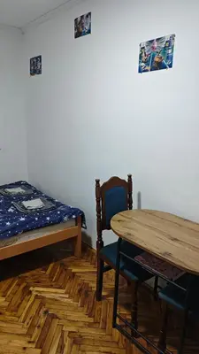 a room with a bed and a table and a chair at hometown in Pančevo