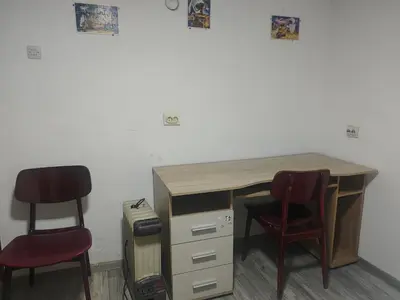a desk with two chairs next to a wall at hometown in Pančevo