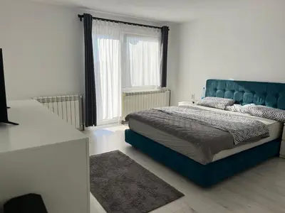 a bedroom with a blue bed and a window at Apartman 100m2 in Belgrade