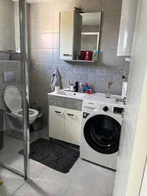 a bathroom with a washing machine and a toilet at Apartman 100m2 in Belgrade